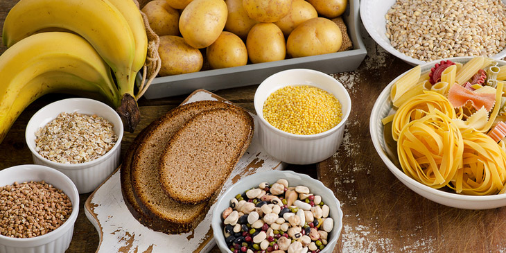 verschiedene kohlenhydratreiche Lebensmittel, wie Bananan, Brot und Nudeln